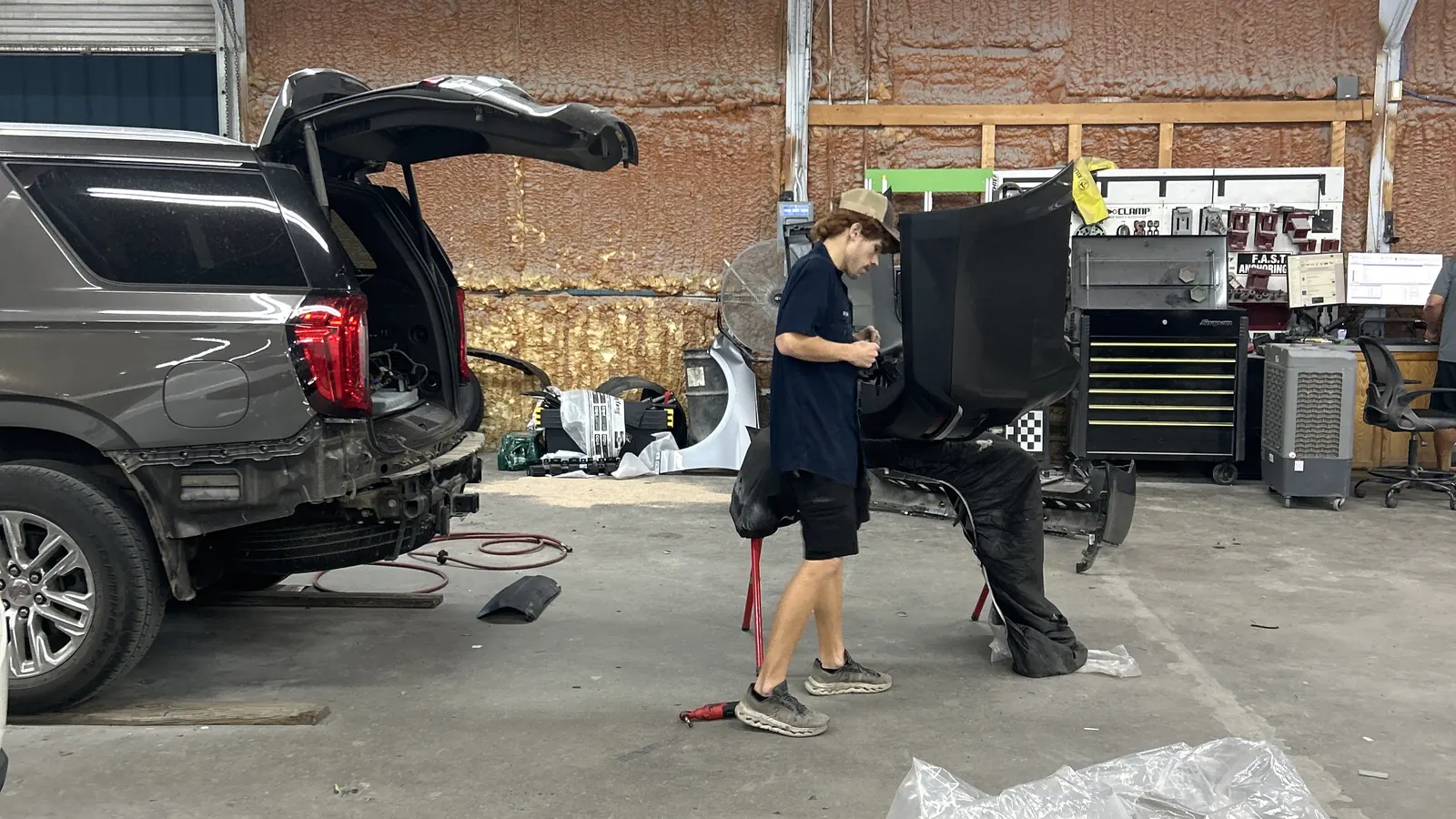 Technician setting up an ADAS calibration target in front of an SUV