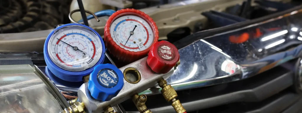 AC manifold gauges connected to a car air conditioning system